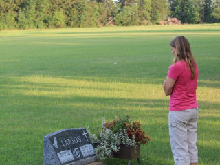 Doris standing by her Dad's grave
