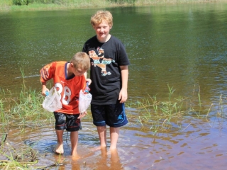 Camping-boys catching minnows-Nephews- Brady looking at Joshua's catch