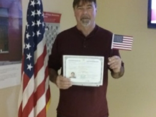 Andy holding his United States Citizenship Certificate.